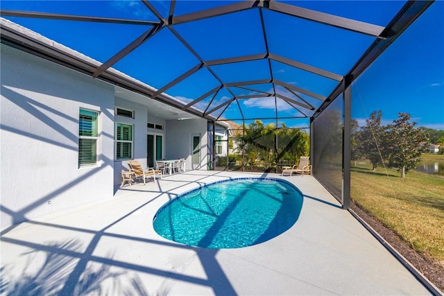 view of swimming pool with a lawn, a patio area, and glass enclosure