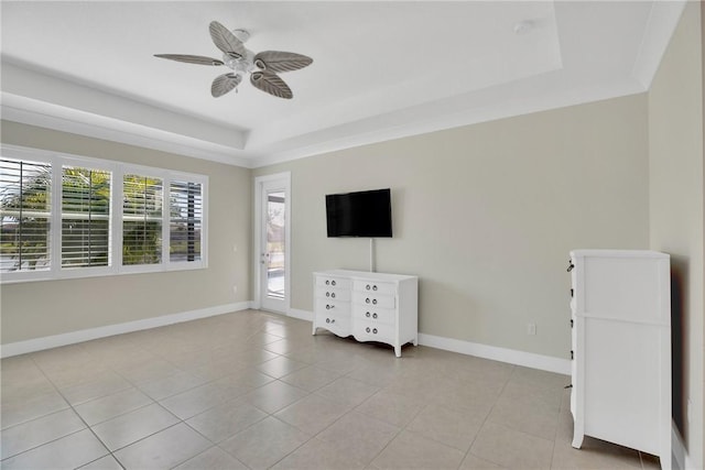 unfurnished bedroom with ceiling fan, a raised ceiling, and light tile patterned floors