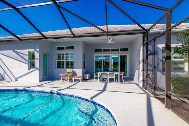 view of swimming pool featuring a patio, ceiling fan, and glass enclosure