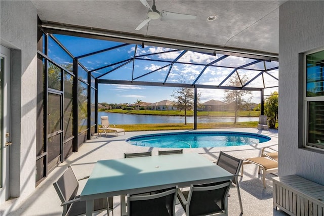 view of swimming pool featuring a lanai, a patio, and a water view