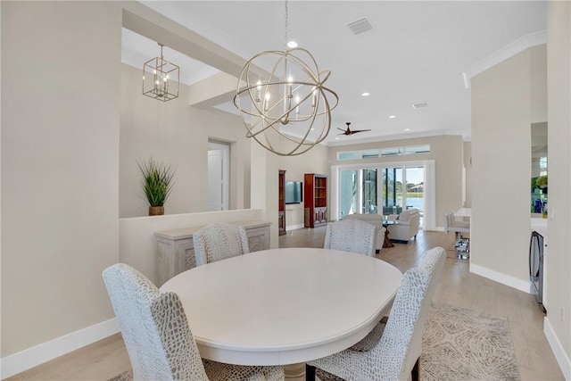 dining space featuring ceiling fan with notable chandelier, ornamental molding, and light hardwood / wood-style floors