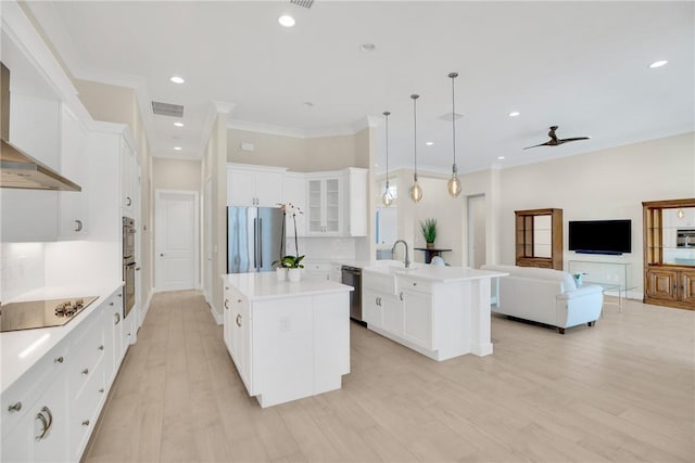 kitchen featuring a kitchen island, white cabinets, appliances with stainless steel finishes, and hanging light fixtures