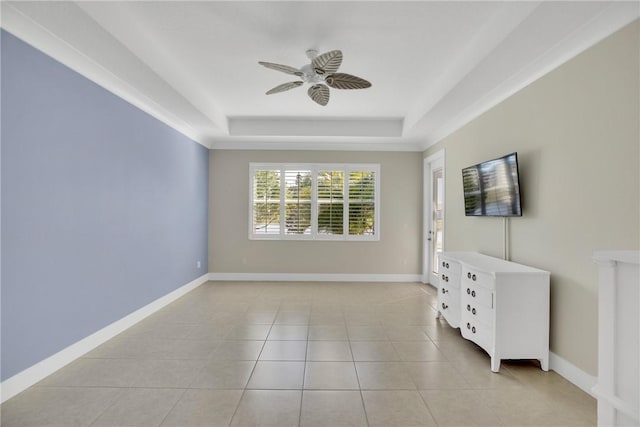 unfurnished living room with ceiling fan, a raised ceiling, and light tile patterned floors