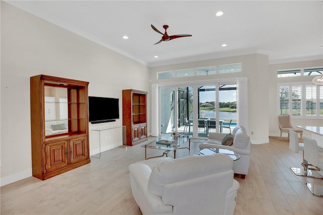 living room with ceiling fan, crown molding, and light hardwood / wood-style flooring