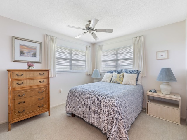 carpeted bedroom with a textured ceiling and ceiling fan