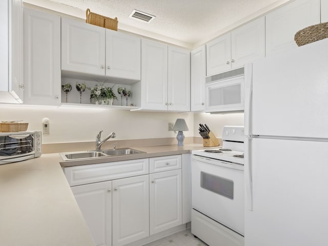 kitchen with a textured ceiling, white appliances, sink, and white cabinets