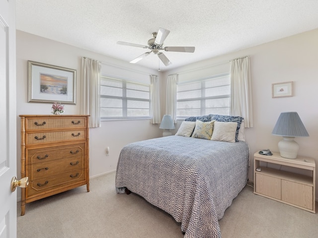 carpeted bedroom featuring a textured ceiling and ceiling fan