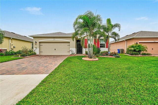2215 Hawk River Dr SW, Vero Beach, FL 32962 - view of front of property featuring stucco siding, a front lawn, decorative driveway, and a garage