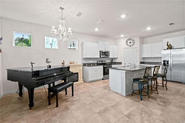 2215 Hawk River Dr SW, Vero Beach, FL 32962 - kitchen featuring a kitchen bar, appliances with stainless steel finishes, an island with sink, and visible vents