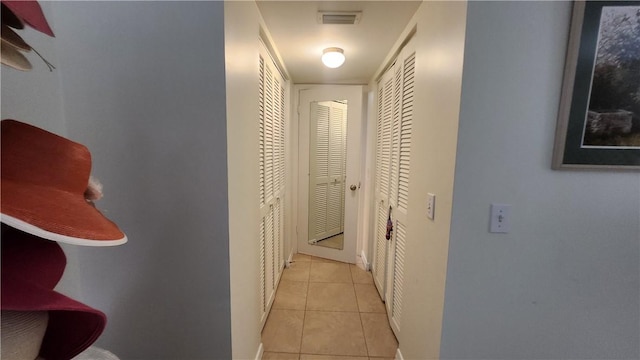 corridor featuring light tile patterned floors and visible vents