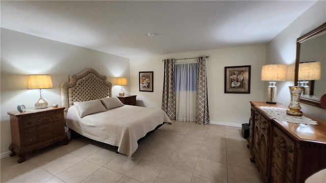 bedroom featuring light tile patterned floors and baseboards