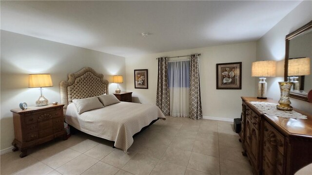 bedroom with baseboards and light tile patterned floors