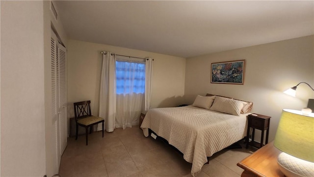 bedroom with a closet and light tile patterned flooring