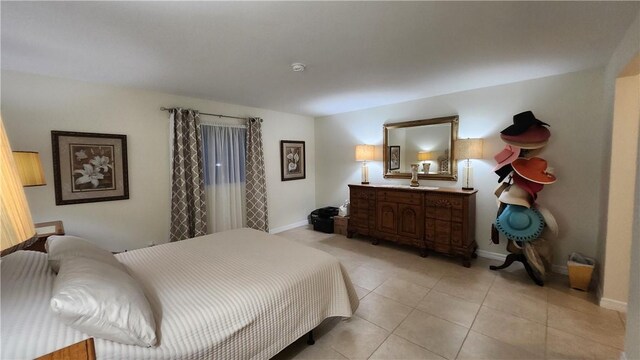 bedroom with light tile patterned flooring and baseboards