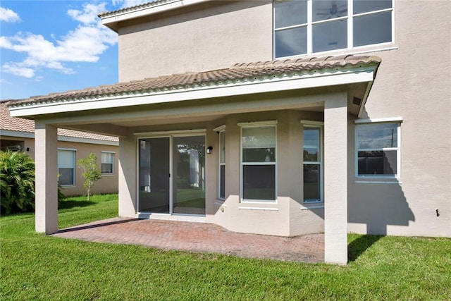 rear view of property featuring a lawn