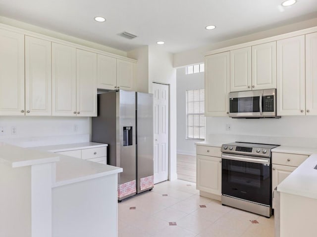 kitchen featuring white cabinetry, light tile patterned flooring, and appliances with stainless steel finishes