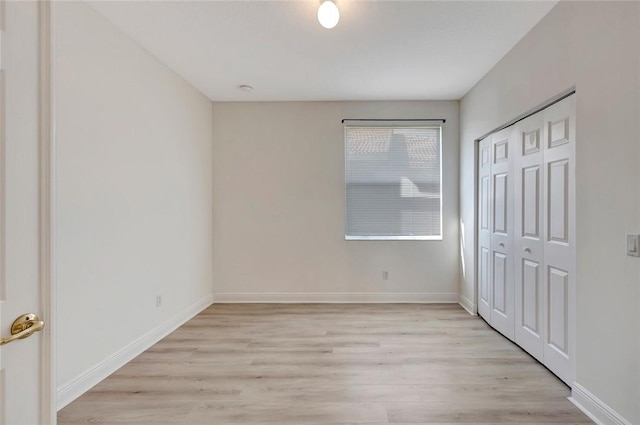 unfurnished bedroom with light hardwood / wood-style floors and a closet