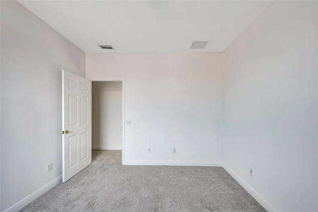 spare room featuring light carpet