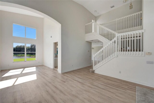 unfurnished living room featuring light hardwood / wood-style flooring and lofted ceiling