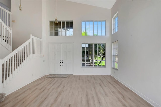 entryway featuring a high ceiling, light hardwood / wood-style flooring, and a notable chandelier