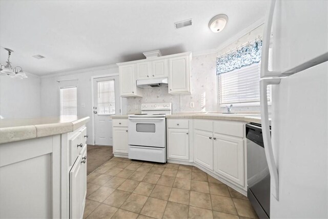 641 Hyacinth Cir, Barefoot Bay, FL 32976 - kitchen with white cabinets, visible vents, white appliances, under cabinet range hood, and tile countertops