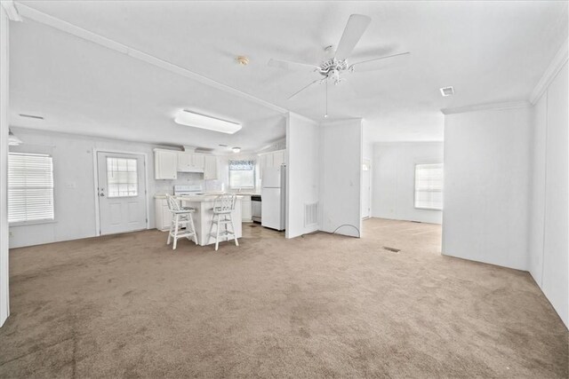 641 Hyacinth Cir, Barefoot Bay, FL 32976 - living area featuring light carpet, a ceiling fan, visible vents, and a wealth of natural light
