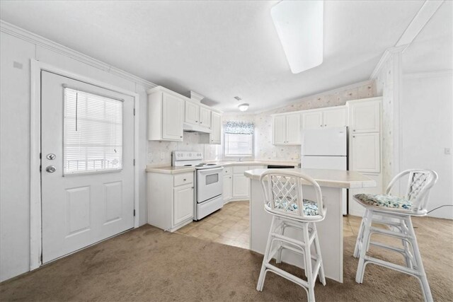 641 Hyacinth Cir, Barefoot Bay, FL 32976 - kitchen with light countertops, a kitchen island, white cabinets, and white appliances
