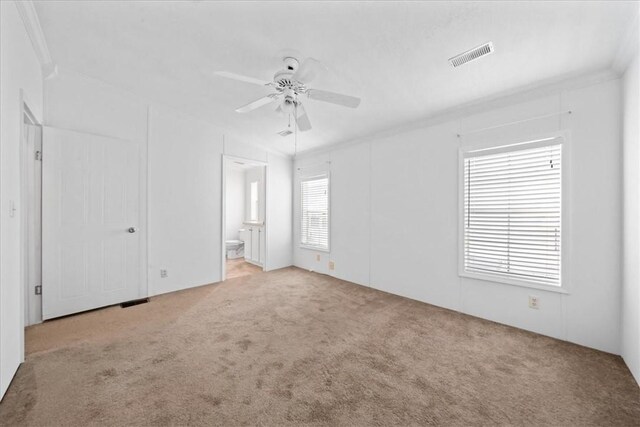 641 Hyacinth Cir, Barefoot Bay, FL 32976 - unfurnished bedroom with ceiling fan, ensuite bathroom, visible vents, and carpet