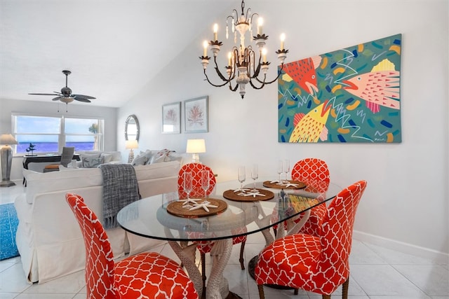 dining area featuring ceiling fan with notable chandelier, vaulted ceiling, and light tile patterned flooring