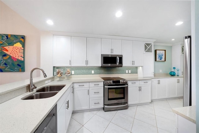 kitchen with appliances with stainless steel finishes, sink, white cabinets, and light stone counters