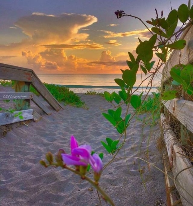 patio terrace at dusk with a water view and a beach view