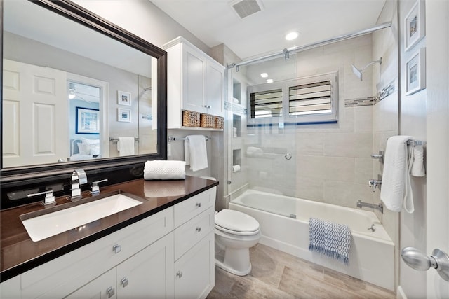 full bathroom featuring toilet, vanity, shower / bath combination with glass door, and tile patterned flooring