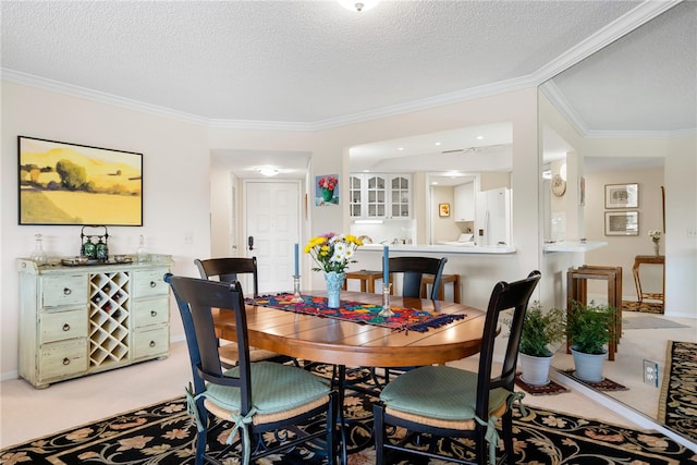 carpeted dining room featuring ornamental molding and a textured ceiling