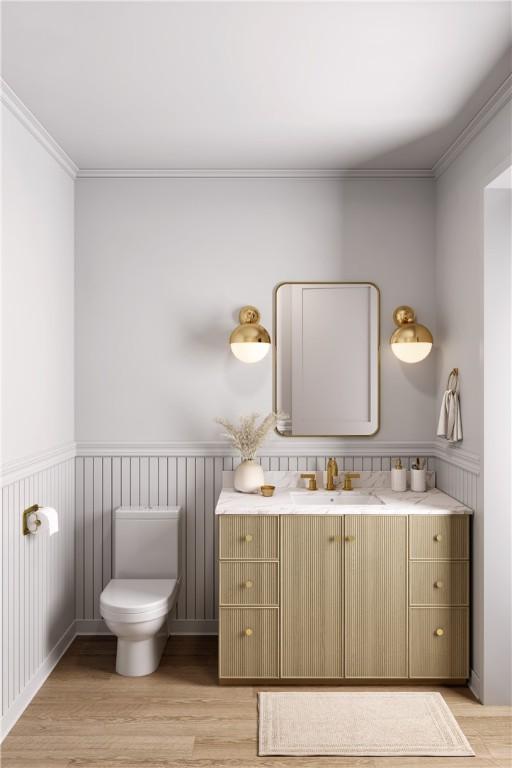 545 Date Palm Rd, Vero Beach, FL 32963 - bathroom with vanity, wood finished floors, toilet, wainscoting, and crown molding
