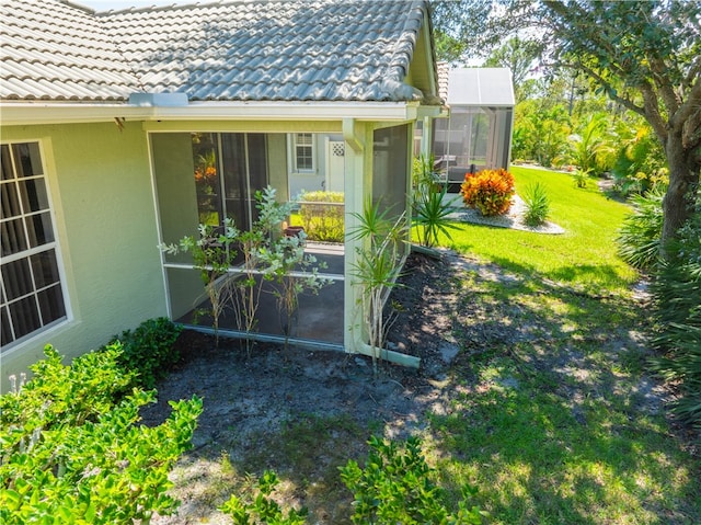 exterior space featuring a lawn and a sunroom