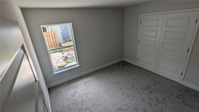 carpeted spare room featuring baseboards