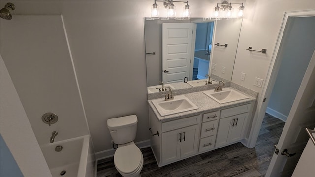 498 Easy St, Sebastian, FL 32958 - full bath with wood finished floors, double vanity, toilet, and baseboards