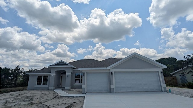ranch-style house with an attached garage, stucco siding, and driveway