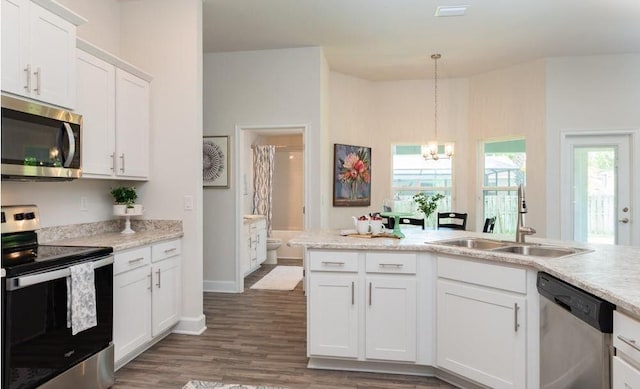 kitchen with a sink, appliances with stainless steel finishes, light countertops, and an inviting chandelier