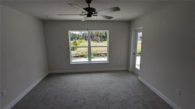 unfurnished room with carpet, ceiling fan, baseboards, and a textured ceiling