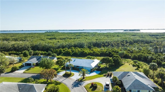 drone / aerial view featuring a view of trees and a water view