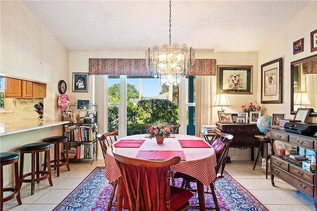 dining area with a textured ceiling, an inviting chandelier, and light tile patterned flooring