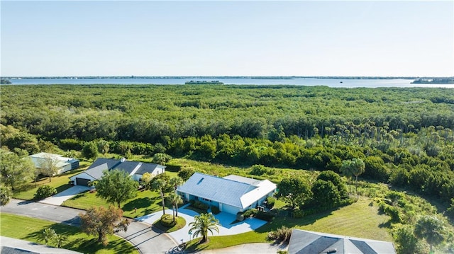 birds eye view of property with a view of trees and a water view