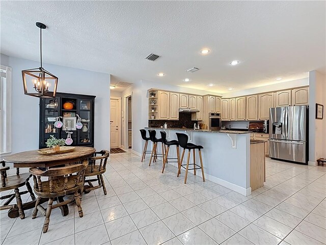 105 Charleston Oaks Dr, Port St Lucie, FL 34983 - kitchen with stainless steel appliances, a kitchen breakfast bar, a peninsula, a chandelier, and open shelves