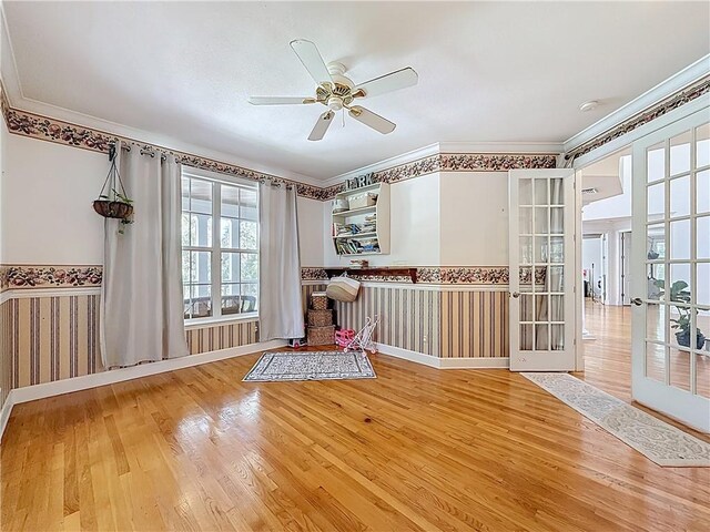 105 Charleston Oaks Dr, Port St Lucie, FL 34983 - unfurnished room featuring wood finished floors, ceiling fan, wallpapered walls, a wainscoted wall, and crown molding