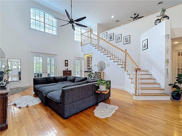 105 Charleston Oaks Dr, Port St Lucie, FL 34983 - living room with ceiling fan, french doors, a high ceiling, light wood-style flooring, and stairs