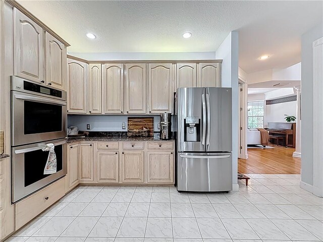 105 Charleston Oaks Dr, Port St Lucie, FL 34983 - kitchen featuring appliances with stainless steel finishes, a textured ceiling, dark stone countertops, light brown cabinets, and recessed lighting