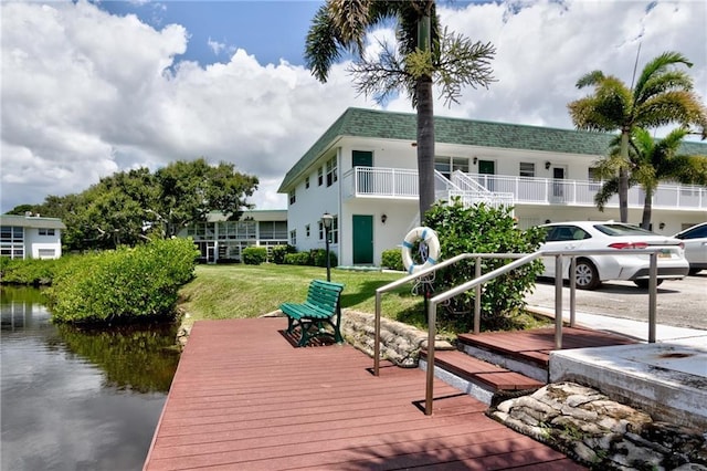 dock area featuring a water view and a lawn