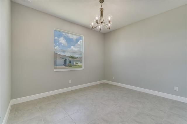 spare room featuring a chandelier and light tile patterned floors