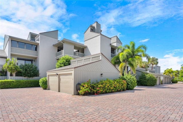 1001 Bay Rd Unit 208-C, Vero Beach, FL 32963 - view of front of house with a chimney, decorative driveway, and stucco siding